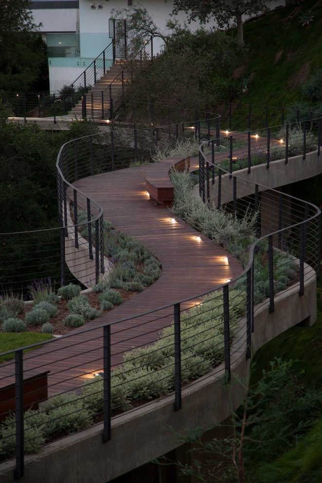 Expansive contemporary sloped full sun formal garden in Los Angeles with a garden path and decking.