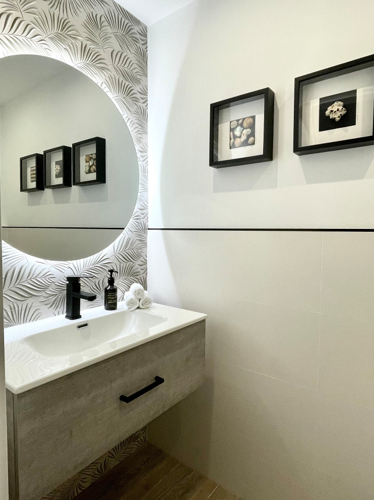 Cette photo montre un WC et toilettes moderne en bois clair de taille moyenne avec un placard en trompe-l'oeil, WC à poser, un carrelage blanc, des carreaux de porcelaine, un mur blanc, un sol en carrelage de porcelaine, un lavabo intégré, un plan de toilette en stéatite, un sol beige, un plan de toilette blanc, meuble-lavabo encastré, un plafond décaissé et un mur en parement de brique.