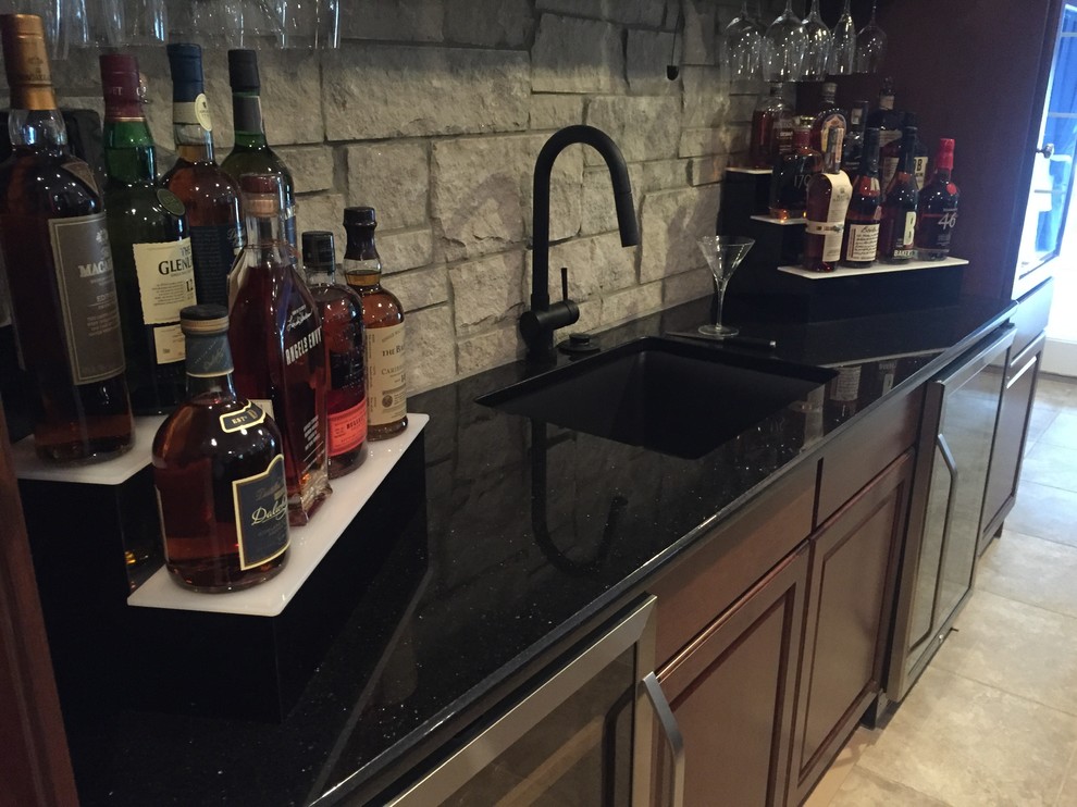 Example of a mid-sized transitional seated home bar design in Philadelphia with an undermount sink, recessed-panel cabinets, medium tone wood cabinets, granite countertops, gray backsplash and stone tile backsplash