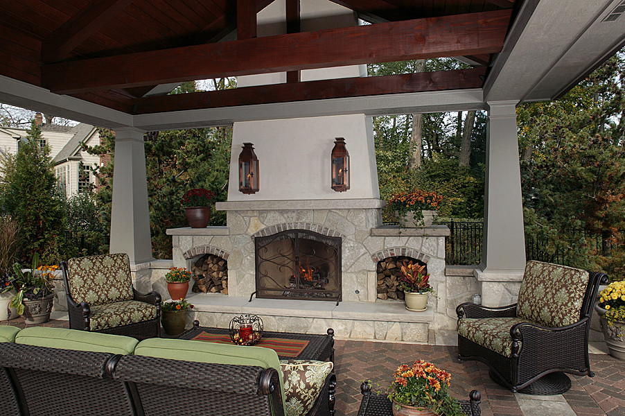 Foto di un patio o portico tradizionale di medie dimensioni e dietro casa con un focolare e pavimentazioni in mattoni