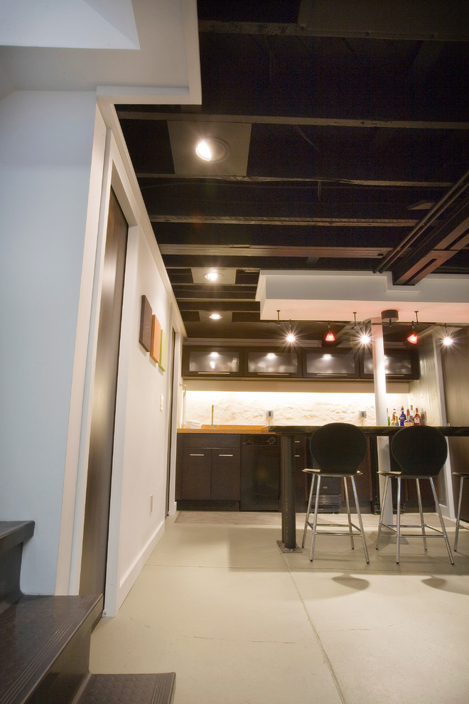 This is an example of a modern basement in Cincinnati with grey floor.
