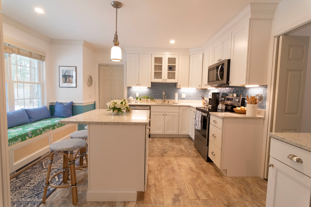 Mid-sized transitional u-shaped beige floor enclosed kitchen photo in Boston with an undermount sink, recessed-panel cabinets, white cabinets, blue backsplash, subway tile backsplash, stainless steel appliances, an island and beige countertops
