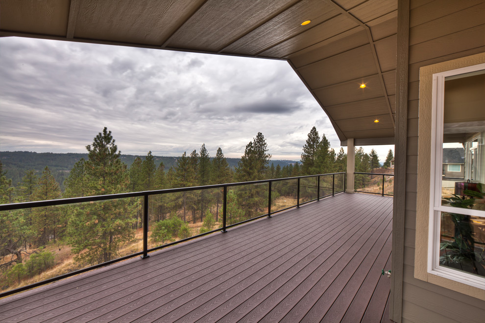 Inspiration for a large transitional backyard deck remodel in Seattle with a roof extension
