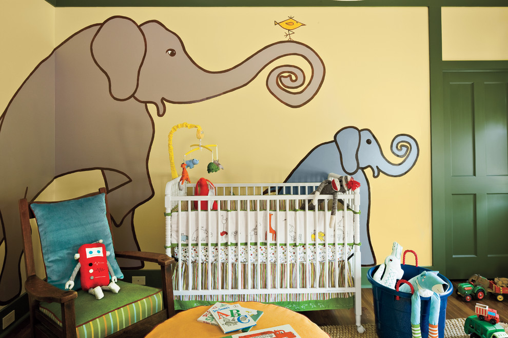 Photo of an eclectic gender-neutral nursery in Atlanta with yellow walls and dark hardwood floors.
