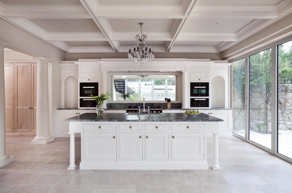 Photo of a large traditional single-wall eat-in kitchen in Dublin with a drop-in sink, shaker cabinets, white cabinets, quartzite benchtops, mirror splashback, black appliances, ceramic floors, with island, grey floor and green benchtop.