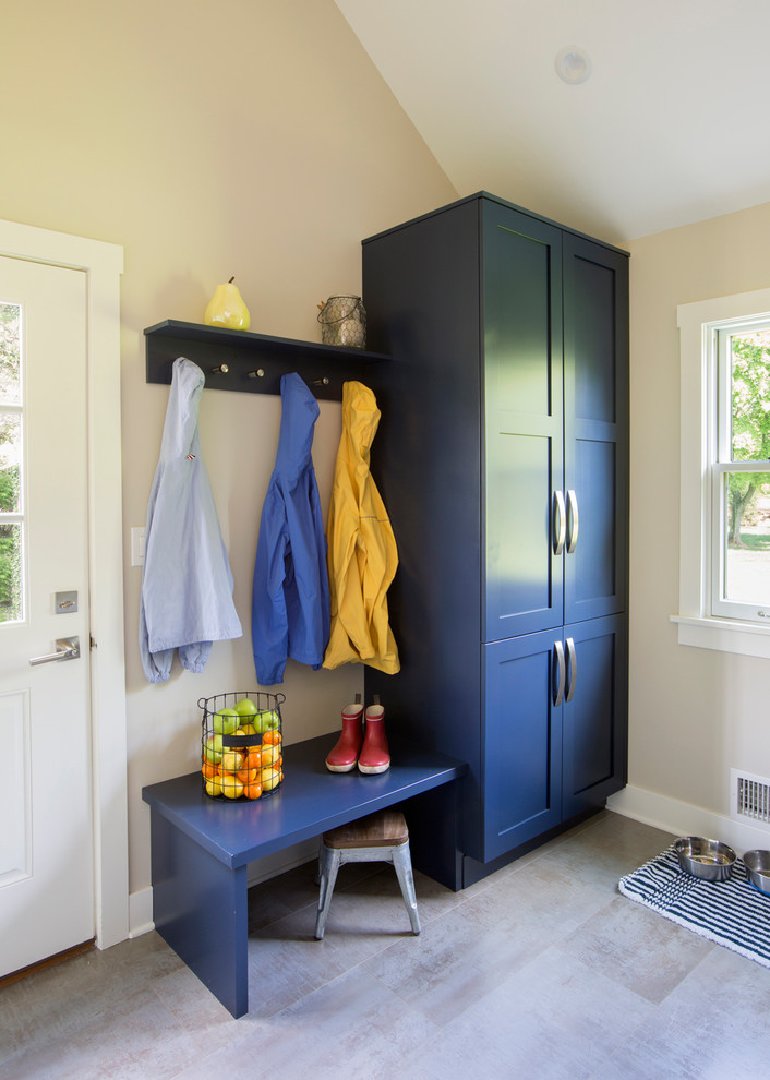 Mid-sized traditional u-shaped utility room in New York with recessed-panel cabinets, blue cabinets, beige walls, ceramic floors and beige floor.