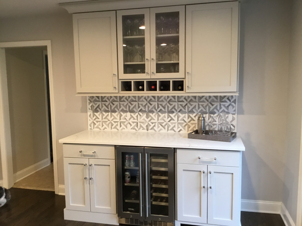 Inspiration for a small contemporary single-wall home bar in New York with beaded inset cabinets, grey cabinets, quartz benchtops, grey splashback, ceramic splashback, dark hardwood floors, brown floor and white benchtop.