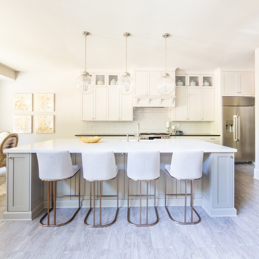 This is an example of a transitional single-wall kitchen in Houston with with island, grey floor, white cabinets, quartz benchtops, white splashback, subway tile splashback, stainless steel appliances, white benchtop, recessed-panel cabinets, a farmhouse sink and porcelain floors.