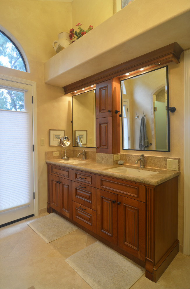 Mittelgroßes Mediterranes Badezimmer En Suite mit profilierten Schrankfronten, dunklen Holzschränken, Travertin, Unterbauwaschbecken, Quarzit-Waschtisch, beiger Waschtischplatte, Doppelwaschbecken und eingebautem Waschtisch in San Luis Obispo