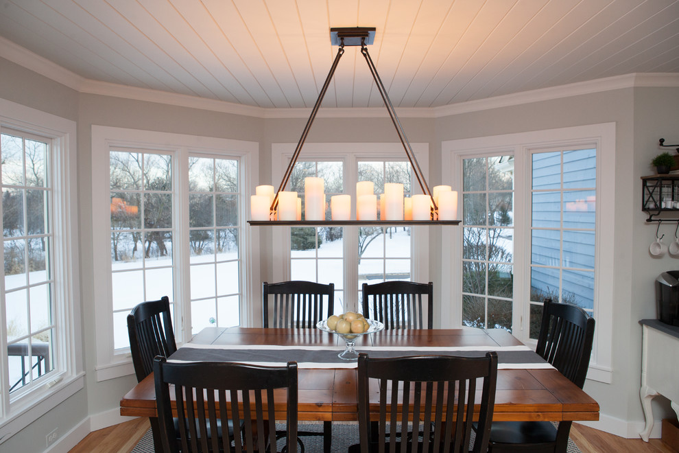 Example of a mid-sized transitional u-shaped light wood floor kitchen/dining room combo design in Chicago with a farmhouse sink, recessed-panel cabinets, white cabinets, quartz countertops, multicolored backsplash, subway tile backsplash, stainless steel appliances and an island