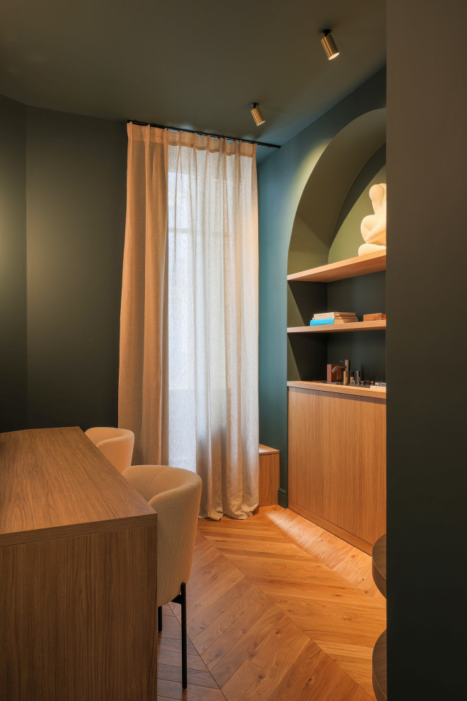Diseño de despacho clásico renovado grande sin chimenea con paredes verdes, suelo de madera clara, escritorio independiente, suelo marrón y papel pintado