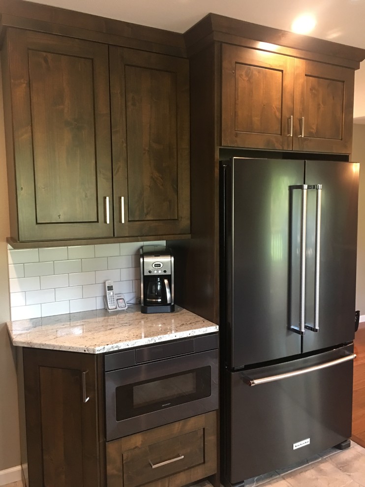 Enclosed kitchen - large transitional l-shaped travertine floor and beige floor enclosed kitchen idea with a double-bowl sink, shaker cabinets, dark wood cabinets, marble countertops, white backsplash, subway tile backsplash, black appliances and an island