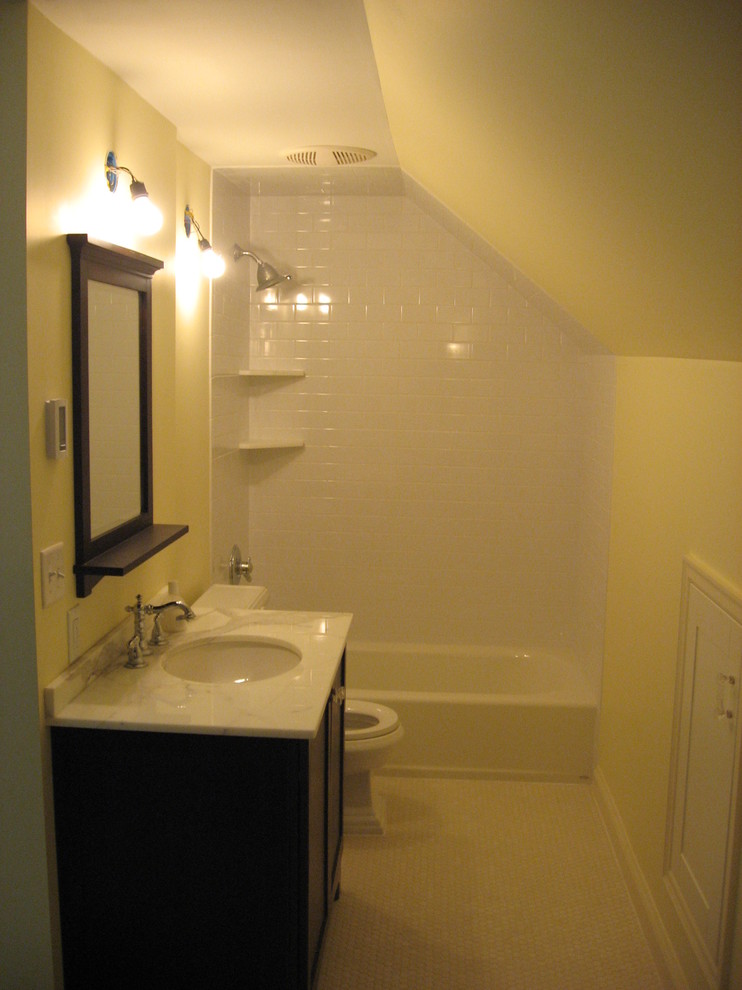 Photo of a small traditional 3/4 bathroom in Minneapolis with shaker cabinets, brown cabinets, an alcove tub, a shower/bathtub combo, a two-piece toilet, white tile, subway tile, orange walls, ceramic floors, an undermount sink and granite benchtops.