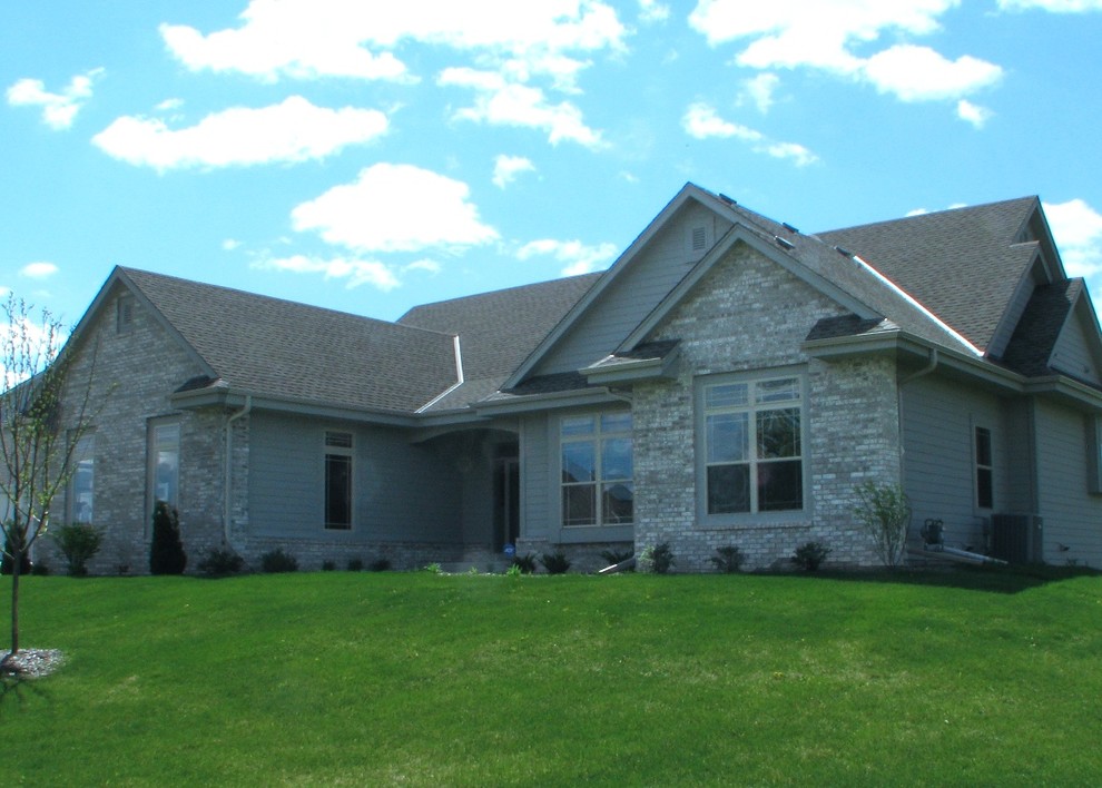 This is an example of a large traditional one-storey grey exterior in Milwaukee with concrete fiberboard siding and a gambrel roof.