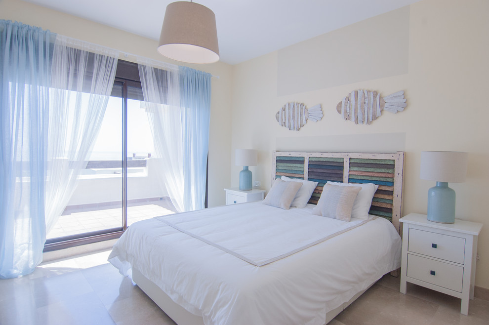 This is an example of a beach style master bedroom in Madrid with beige walls and beige floor.