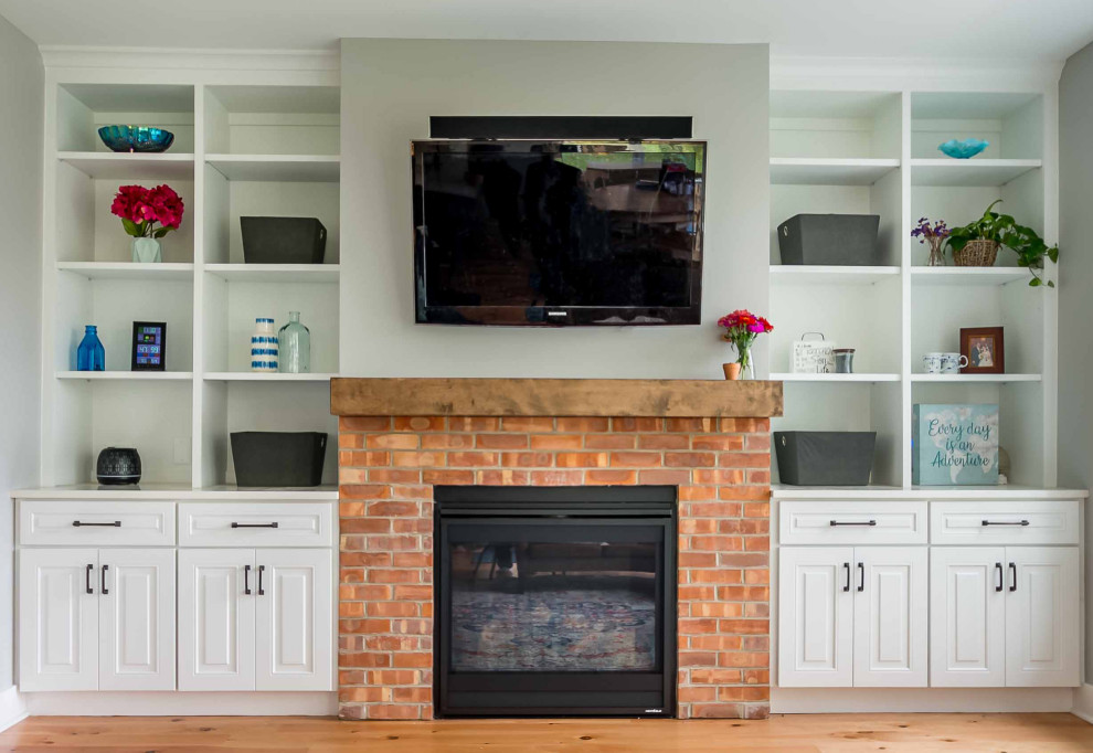 Photo of a mid-sized country open concept living room in Chicago with white walls, light hardwood floors, a standard fireplace, a brick fireplace surround, a wall-mounted tv, brown floor, wallpaper and wallpaper.