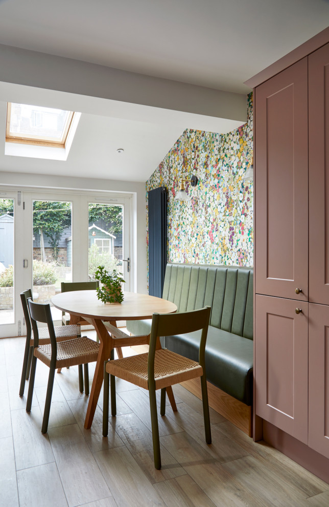 Mid-sized modern galley eat-in kitchen in London with a farmhouse sink, shaker cabinets, pink cabinets, marble benchtops, white splashback, ceramic splashback, stainless steel appliances, ceramic floors, no island and white benchtop.