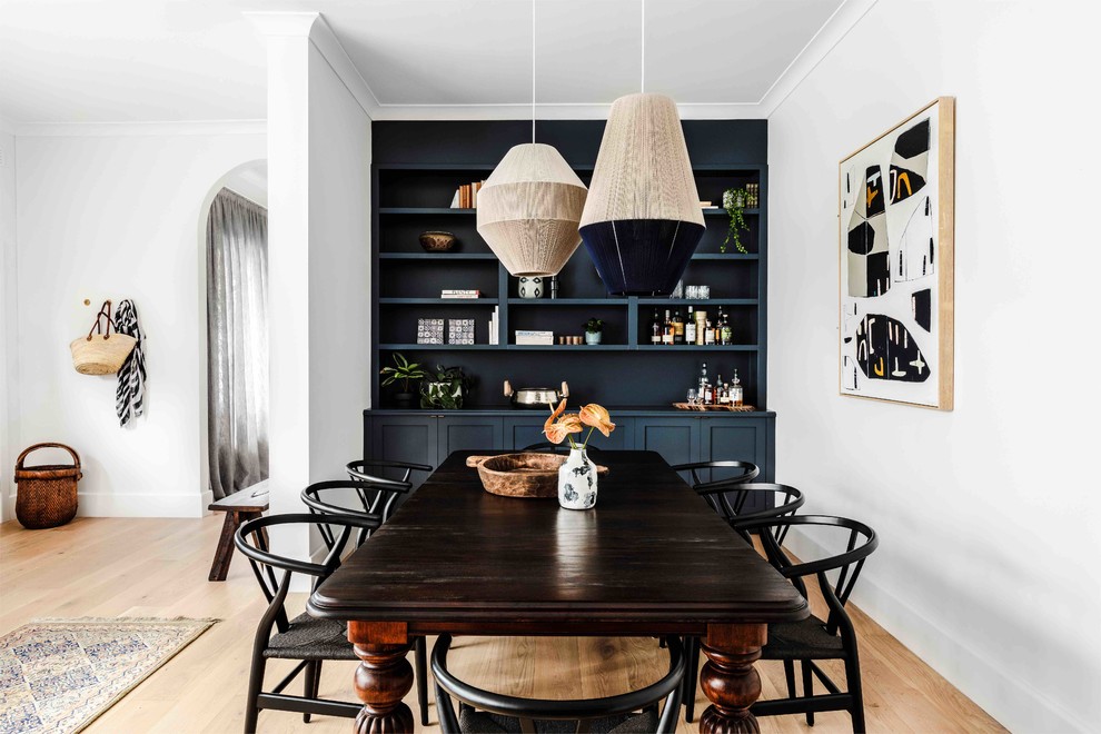 Design ideas for an eclectic dining room in Melbourne with white walls, light hardwood floors and beige floor.