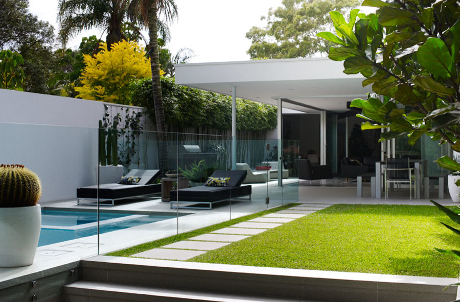 Inspiration for a mid-sized contemporary backyard partial sun formal garden in Sydney with concrete pavers.