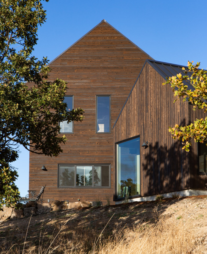 На фото: двухэтажный, деревянный дом среднего размера в стиле кантри с