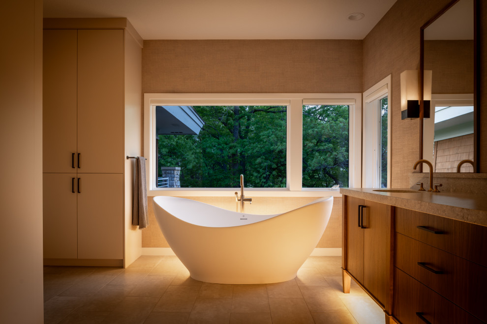 Example of a mid-sized trendy master marble floor, beige floor, double-sink and vaulted ceiling bathroom design in Minneapolis with flat-panel cabinets, medium tone wood cabinets, an undermount sink, granite countertops, a niche and a built-in vanity