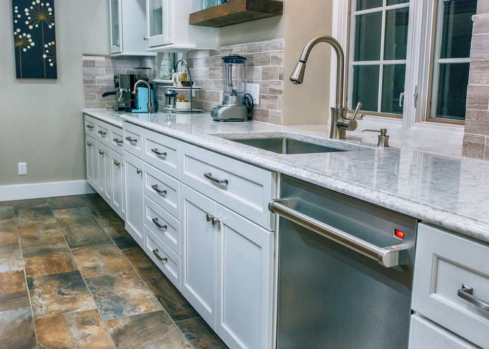 Kitchen - small transitional kitchen idea with an undermount sink, beige backsplash, ceramic backsplash, stainless steel appliances and an island