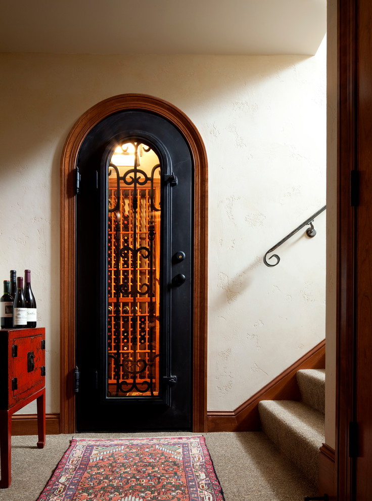 Photo of a mid-sized mediterranean wine cellar in Minneapolis with carpet and storage racks.