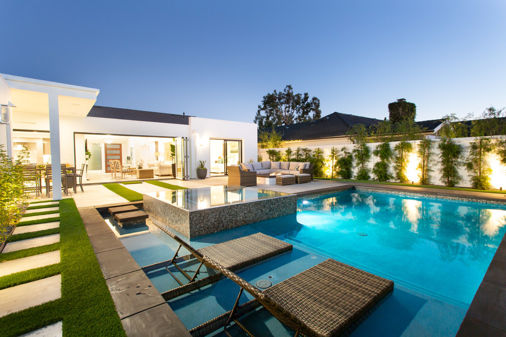 Inspiration for a contemporary backyard rectangular pool in Orange County with a hot tub and concrete pavers.