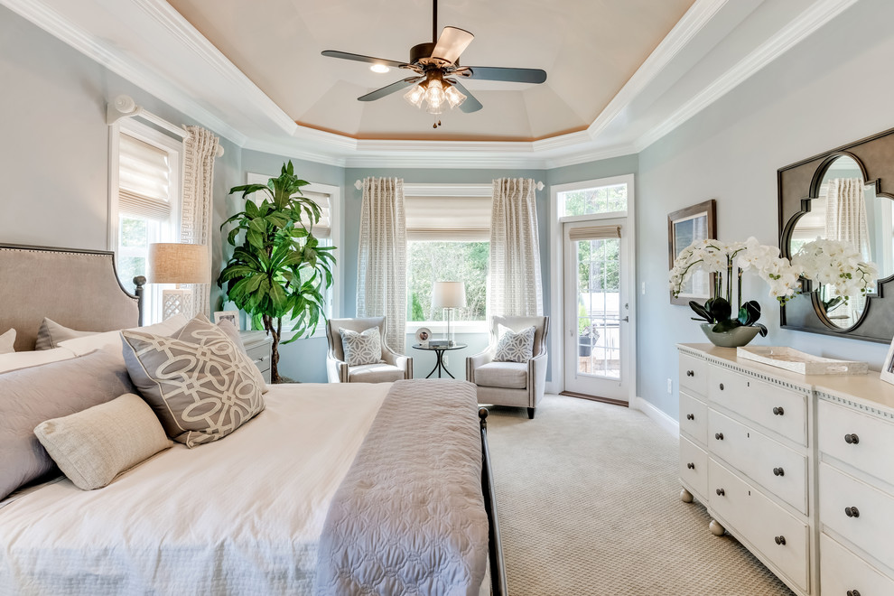 Large traditional master bedroom in Other with blue walls, carpet and beige floor.