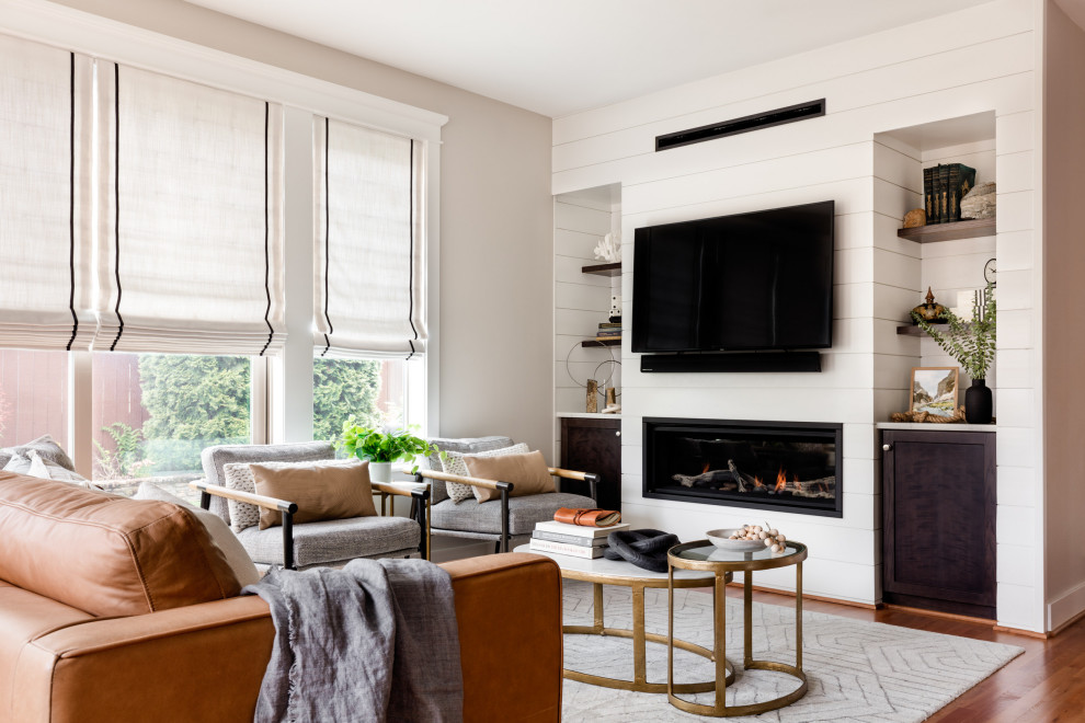На фото: открытая гостиная комната среднего размера в стиле неоклассика (современная классика) с белыми стенами, горизонтальным камином, фасадом камина из вагонки и телевизором на стене