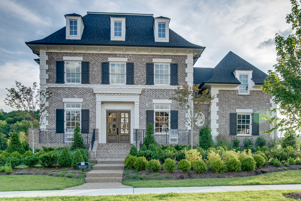 Large traditional three-storey brick grey exterior in Nashville with a hip roof.