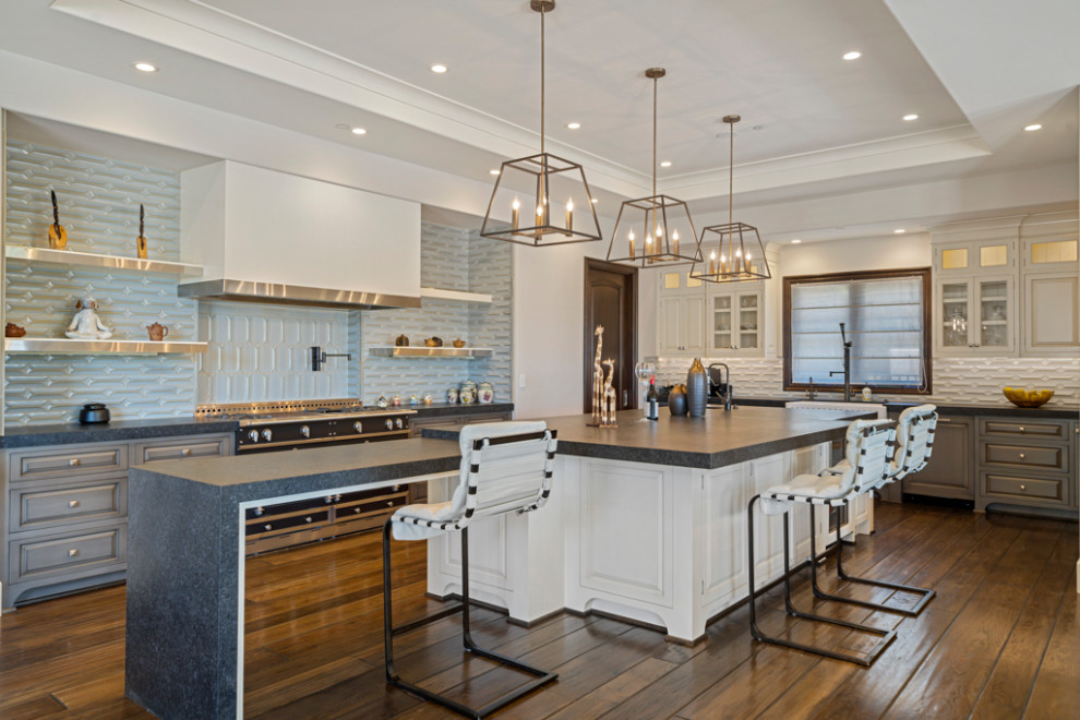 Eat-in kitchen - large transitional u-shaped dark wood floor and brown floor eat-in kitchen idea in Orange County with a farmhouse sink, raised-panel cabinets, gray cabinets, quartz countertops, gray backsplash, black appliances, two islands and gray countertops