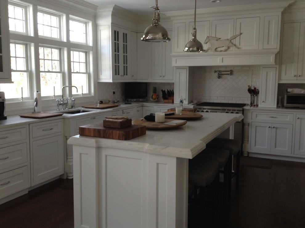 Mid-sized transitional kitchen in New York with recessed-panel cabinets, dark hardwood floors and with island.