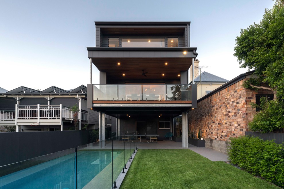 Contemporary three-storey grey house exterior in Brisbane with a gable roof and a metal roof.