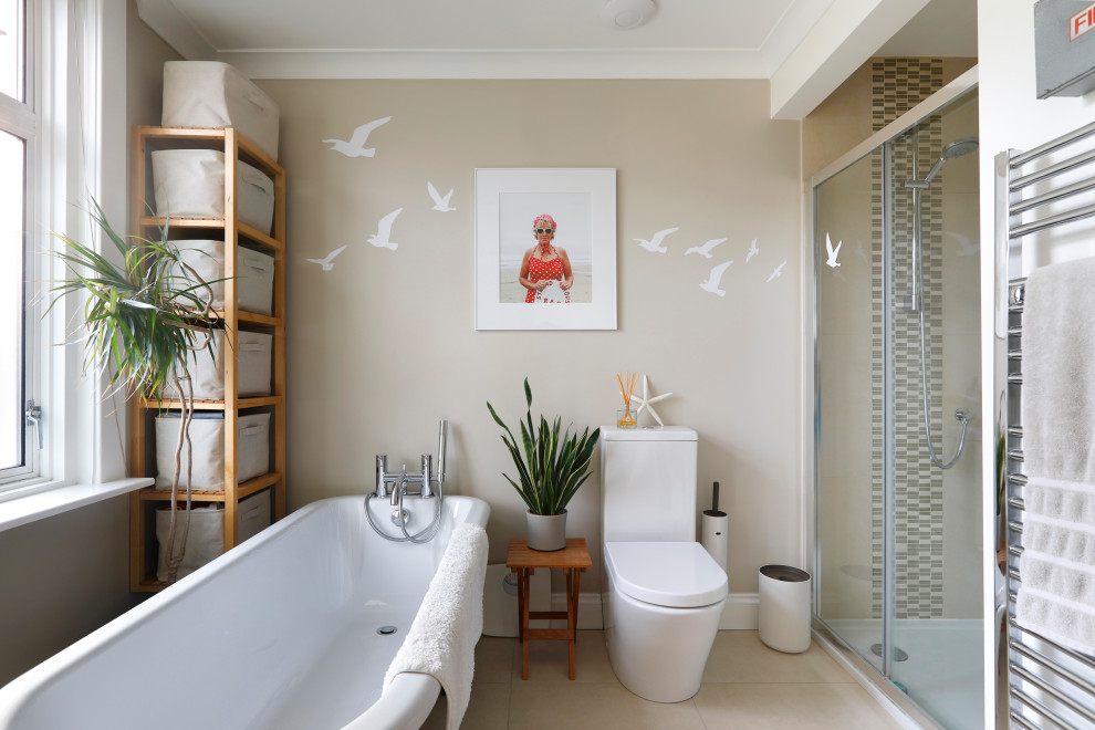 Photo of a small contemporary family bathroom in Sussex with a freestanding bath, a two-piece toilet, beige tiles, mosaic tiles, beige walls, ceramic flooring, a wall-mounted sink, beige floors, a sliding door, a single sink and a walk-in shower.