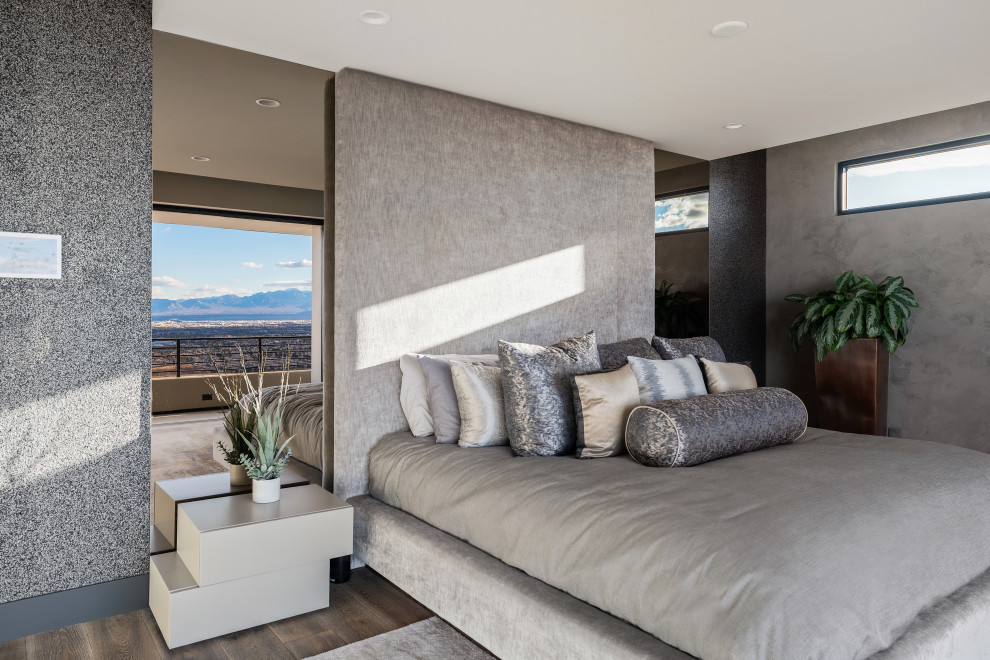 Cette photo montre une chambre moderne avec un mur gris, parquet foncé et un sol marron.