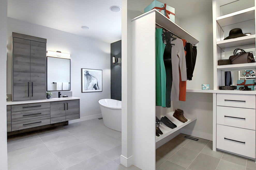 This is an example of a mid-sized industrial gender-neutral storage and wardrobe in Calgary with open cabinets, white cabinets, ceramic floors and grey floor.