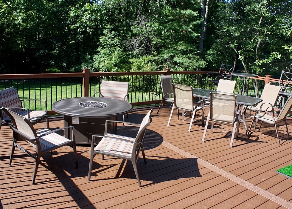 Example of a mid-sized transitional backyard deck design in Philadelphia with a fire pit and no cover