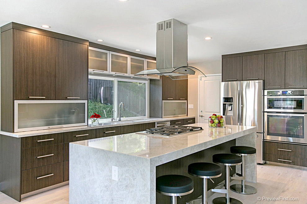 Design ideas for a mid-sized contemporary open plan kitchen in San Diego with a double-bowl sink, flat-panel cabinets, dark wood cabinets, quartzite benchtops, stainless steel appliances, light hardwood floors and with island.