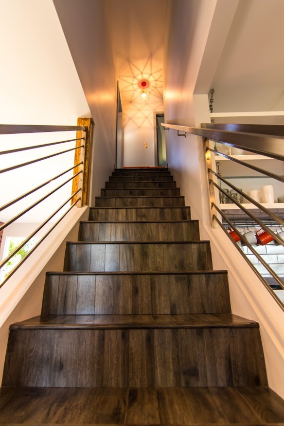 Photo of a mid-sized modern wood straight staircase in Vancouver with wood risers and metal railing.