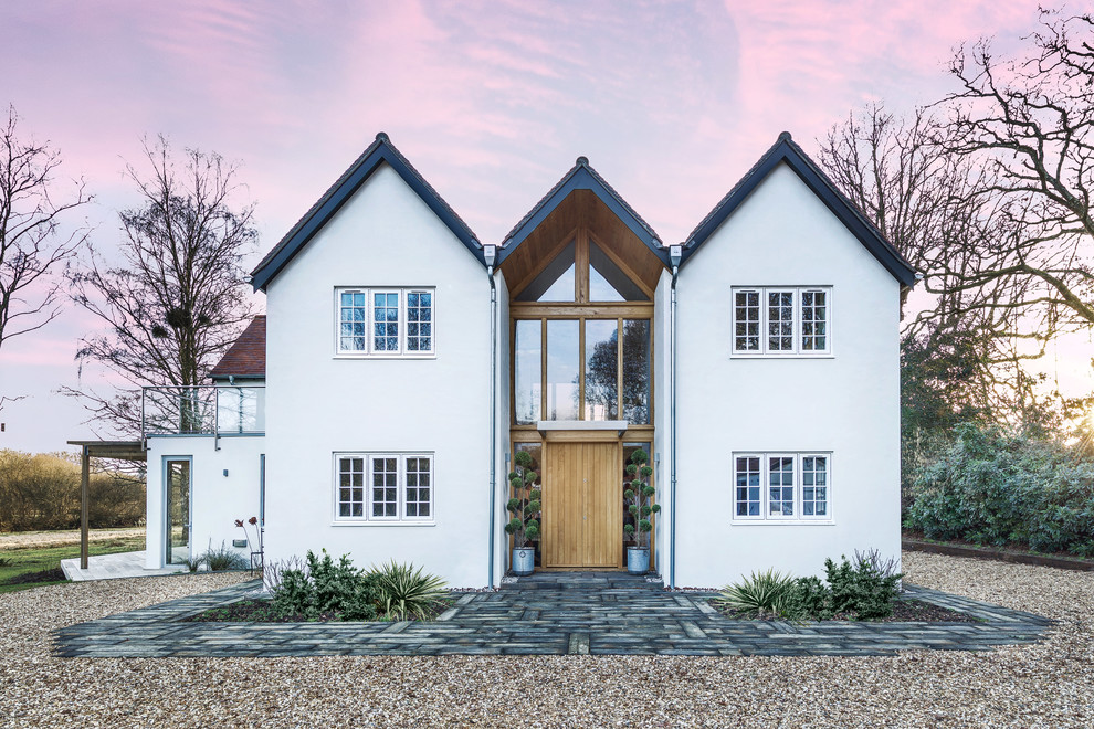 Transitional two-storey stucco white house exterior in Hampshire with a gable roof.