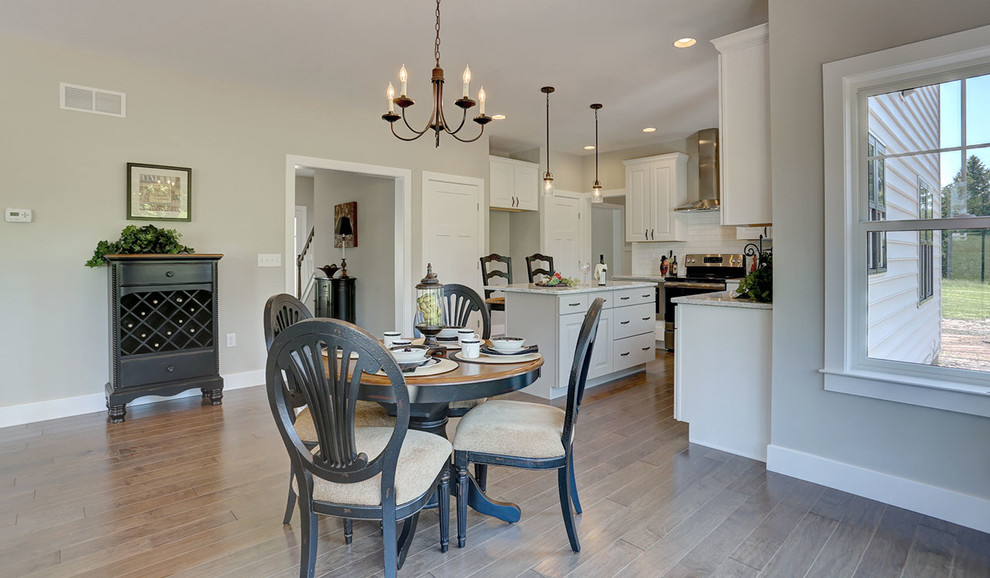 Inspiration for a mid-sized country kitchen/dining combo in Other with beige walls and medium hardwood floors.