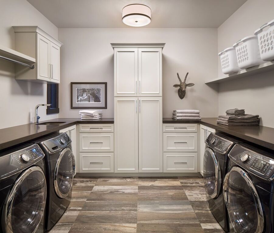 This is an example of a large country u-shaped dedicated laundry room in Other with an undermount sink, beaded inset cabinets, white cabinets, quartz benchtops, grey walls, medium hardwood floors, a side-by-side washer and dryer and multi-coloured floor.