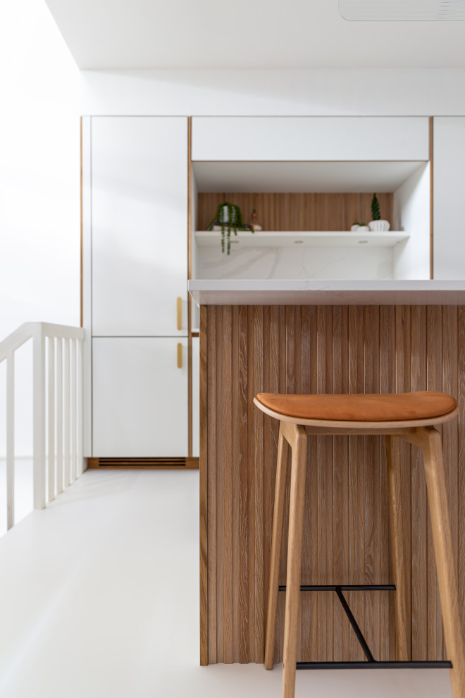 Immagine di una piccola cucina lineare scandinava con ante lisce, ante bianche, top in superficie solida, paraspruzzi bianco, elettrodomestici bianchi e top bianco