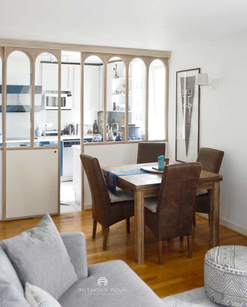 Inspiration pour une petite salle à manger ouverte sur le salon marine avec un mur blanc, un sol en bois brun, une cheminée double-face, un manteau de cheminée en métal et verrière.
