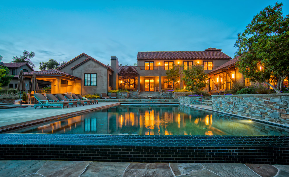 Example of a large tuscan backyard concrete and rectangular infinity hot tub design in San Francisco