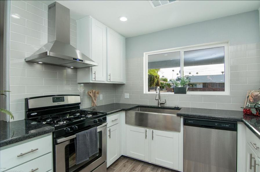 Open concept kitchen - mid-sized u-shaped open concept kitchen idea in Phoenix with recessed-panel cabinets, white cabinets, gray backsplash, subway tile backsplash, stainless steel appliances and no island