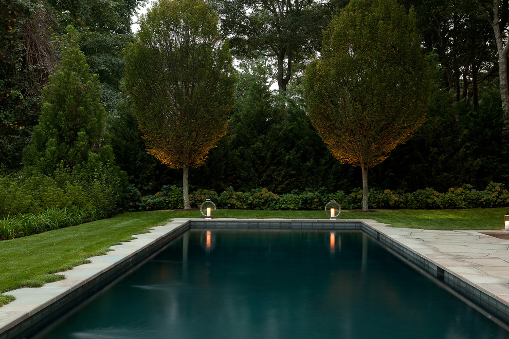 Photo of a mid-sized traditional backyard rectangular lap pool in New York with a hot tub and natural stone pavers.