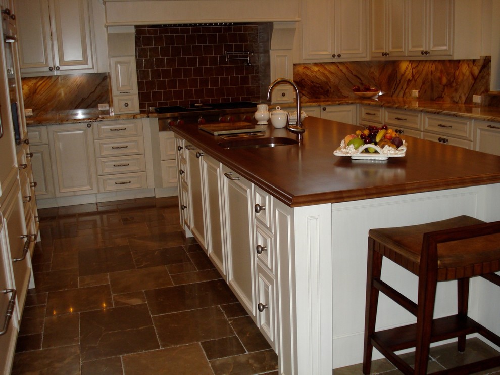 Large transitional u-shaped limestone floor open concept kitchen photo in Miami with an undermount sink, raised-panel cabinets, white cabinets, onyx countertops, multicolored backsplash, paneled appliances and an island
