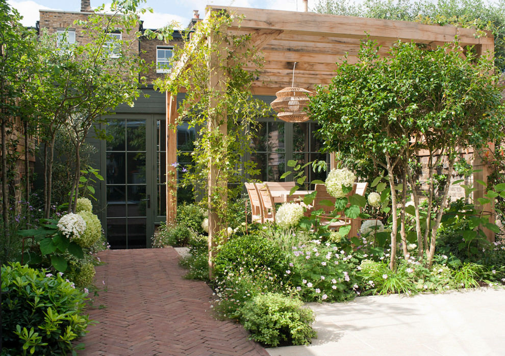 Foto di un piccolo giardino contemporaneo esposto in pieno sole dietro casa in estate con un ingresso o sentiero e pavimentazioni in mattoni